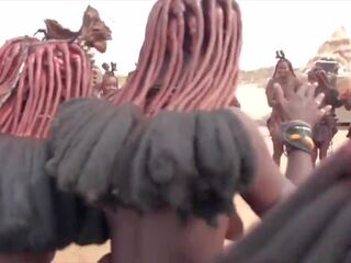 Afrikāņu himba sievietes deja un šūpoles viņu saggy bumbulīši apkārt